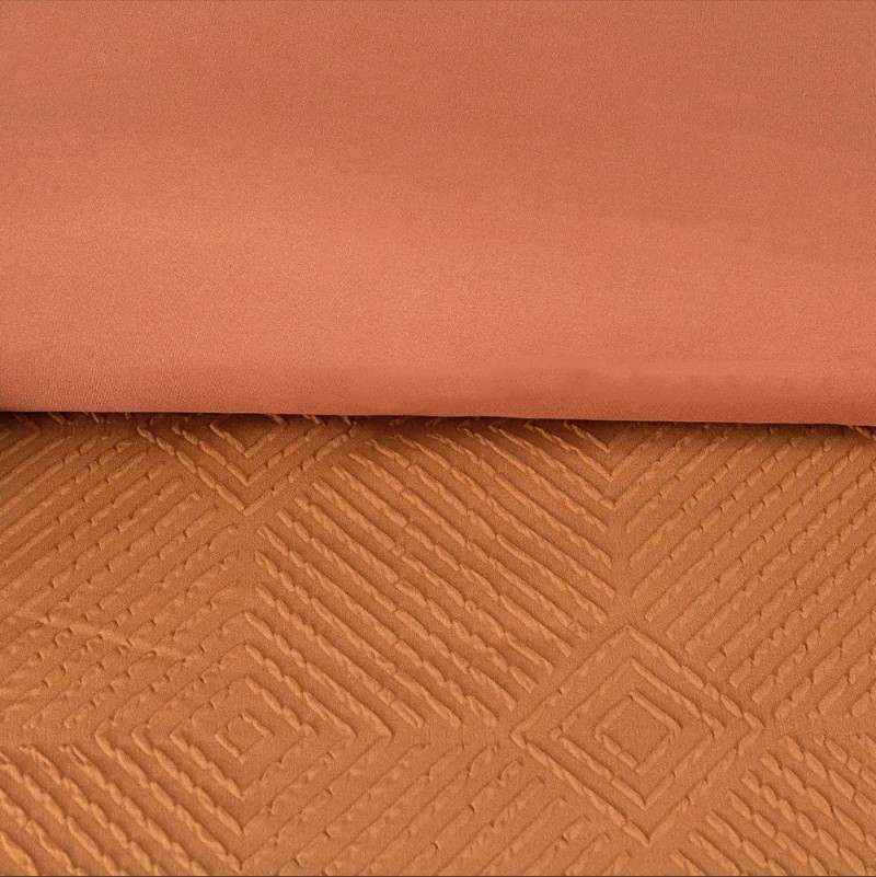 Paano makadagdag sa geometric embossed bedding na may mga kasangkapan sa silid-tulugan?